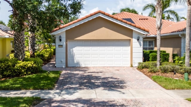 12041 Kajetan Ln, Orlando, FL 32827 - view of front of house featuring a tile roof, decorative driveway, stucco siding, and a garage