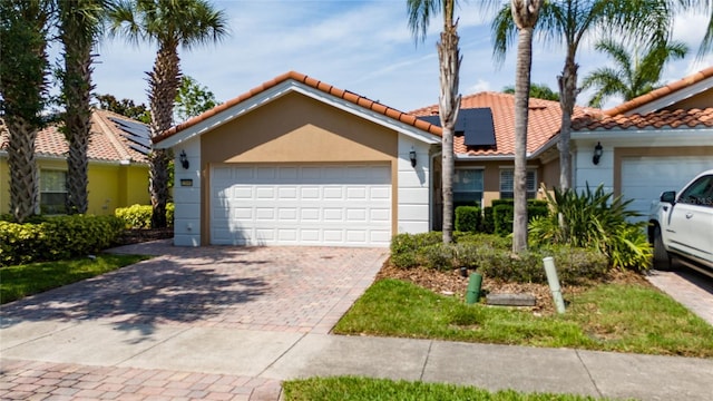 12041 Kajetan Ln, Orlando, FL 32827 - view of front of house with stucco siding, a tiled roof, solar panels, driveway, and a garage