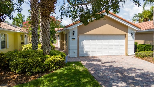 12041 Kajetan Ln, Orlando, FL 32827 - mediterranean / spanish home featuring decorative driveway, stucco siding, an attached garage, and a tile roof