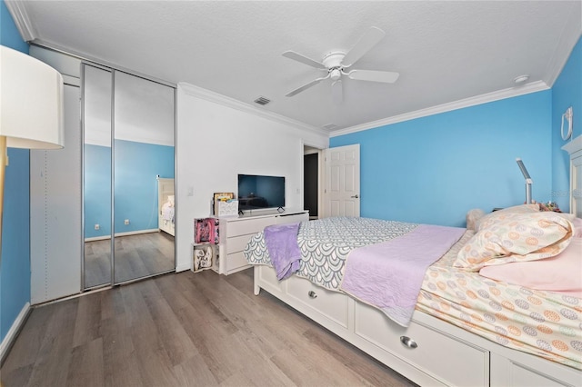 12041 Kajetan Ln, Orlando, FL 32827 - bedroom with wood finished floors, ornamental molding, ceiling fan, baseboards, and a closet