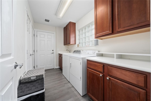 12041 Kajetan Ln, Orlando, FL 32827 - laundry room with cabinet space, light wood finished floors, and washer and clothes dryer