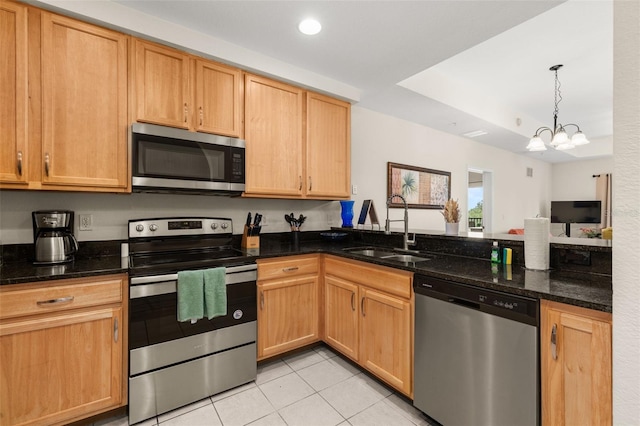 9055 Treasure Trove Ln Unit 409, Kissimmee, FL 34747 - kitchen with stainless steel appliances, a sink, light tile patterned flooring, a peninsula, and dark stone countertops