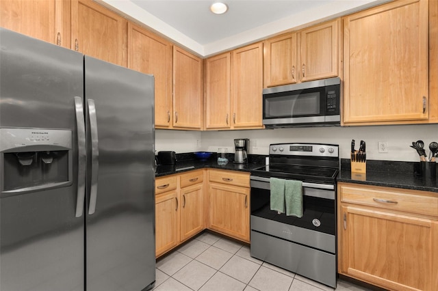 9055 Treasure Trove Ln Unit 409, Kissimmee, FL 34747 - kitchen featuring appliances with stainless steel finishes, light tile patterned floors, dark stone counters, and light brown cabinets