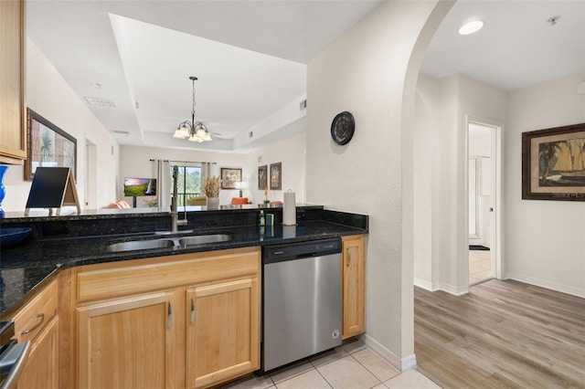 9055 Treasure Trove Ln Unit 409, Kissimmee, FL 34747 - kitchen featuring dishwasher, a sink, arched walkways, a tray ceiling, and dark stone countertops