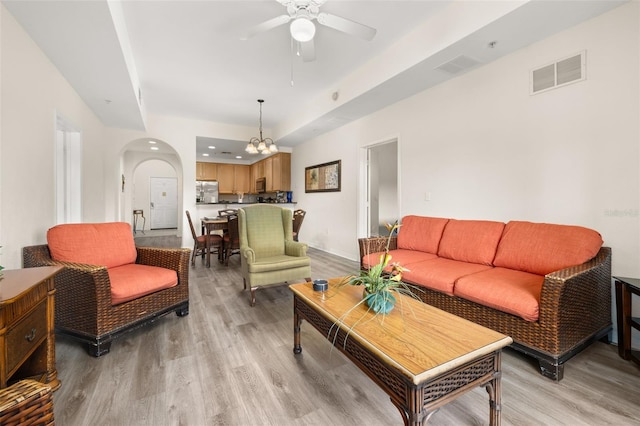 9055 Treasure Trove Ln Unit 409, Kissimmee, FL 34747 - living room featuring arched walkways, a ceiling fan, and light wood-type flooring