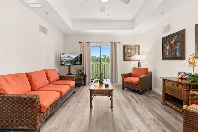 9055 Treasure Trove Ln Unit 409, Kissimmee, FL 34747 - living area featuring a raised ceiling, light wood finished floors, a ceiling fan, and baseboards