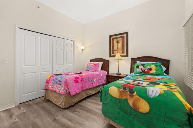 9055 Treasure Trove Ln Unit 409, Kissimmee, FL 34747 - bedroom featuring wood finished floors, a closet, and baseboards