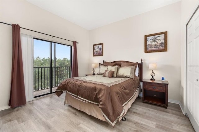 9055 Treasure Trove Ln Unit 409, Kissimmee, FL 34747 - bedroom featuring access to exterior, light wood-style flooring, and baseboards