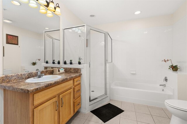 9055 Treasure Trove Ln Unit 409, Kissimmee, FL 34747 - bathroom featuring toilet, vanity, tile patterned floors, a stall shower, and a bathtub