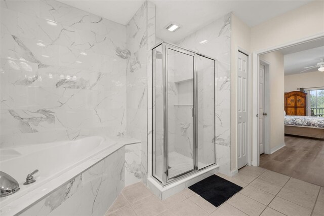 9055 Treasure Trove Ln Unit 409, Kissimmee, FL 34747 - ensuite bathroom featuring a garden tub, a marble finish shower, ceiling fan, and tile patterned floors