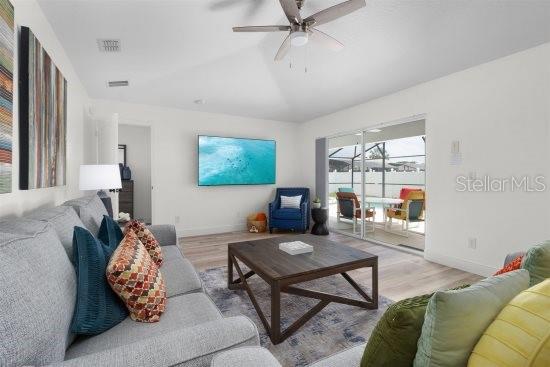 252 Barbera Dr, Davenport, FL 33897 - living area featuring wood finished floors, a ceiling fan, vaulted ceiling, and baseboards