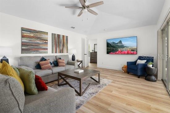 252 Barbera Dr, Davenport, FL 33897 - living room with ceiling fan, light wood-style floors, vaulted ceiling, and baseboards