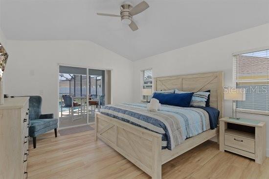 252 Barbera Dr, Davenport, FL 33897 - bedroom featuring lofted ceiling, light wood-style floors, access to exterior, and ceiling fan