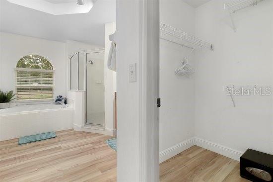 252 Barbera Dr, Davenport, FL 33897 - full bathroom with wood finished floors, a shower stall, and a bath