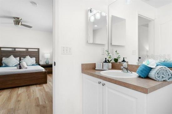 252 Barbera Dr, Davenport, FL 33897 - bathroom featuring ensuite bath, vanity, a ceiling fan, and wood finished floors