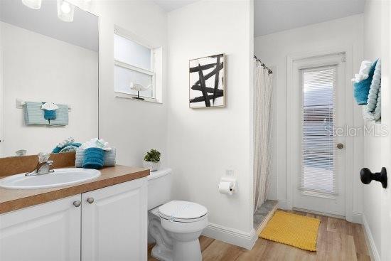 252 Barbera Dr, Davenport, FL 33897 - bathroom with wood finished floors, vanity, toilet, and curtained shower