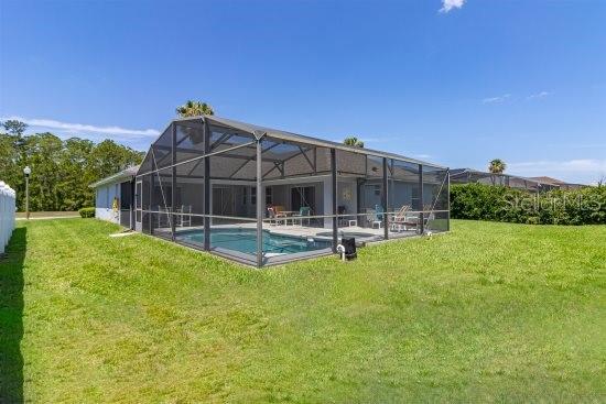 252 Barbera Dr, Davenport, FL 33897 - back of property with a lawn, an outdoor pool, and a patio area
