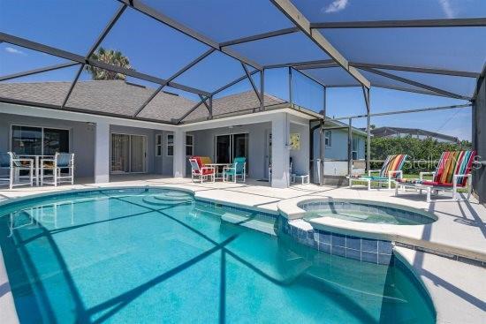 252 Barbera Dr, Davenport, FL 33897 - view of pool with a patio area, a pool with connected hot tub, a lanai, and outdoor dining space