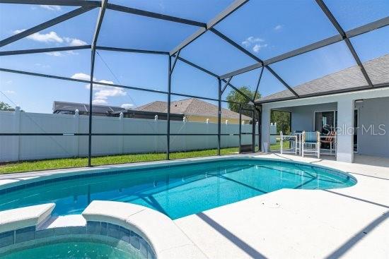 252 Barbera Dr, Davenport, FL 33897 - view of pool featuring a patio area, a pool with connected hot tub, and glass enclosure