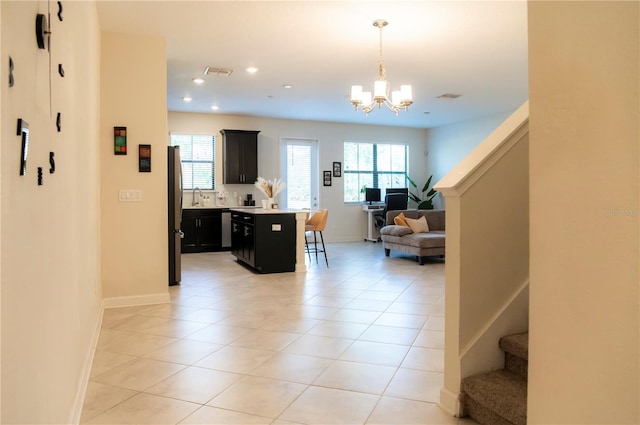 11378 Whistling Pine Way, Orlando, FL 32832 - kitchen with dark cabinetry, open floor plan, a kitchen bar, appliances with stainless steel finishes, and light countertops