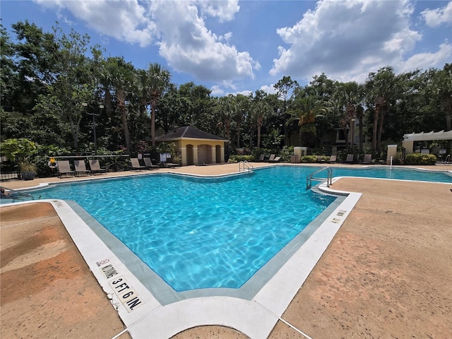 2572 Robert Trent Jones Dr Unit 1227, Orlando, FL 32835 - community pool with view of scattered trees and a patio area