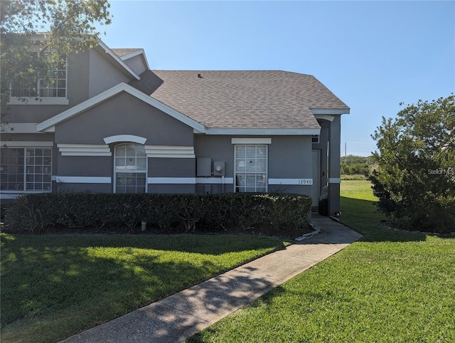 13940 Corrine Key Pl, Orlando, FL 32824 - view of front of property with a front yard, stucco siding, and a shingled roof