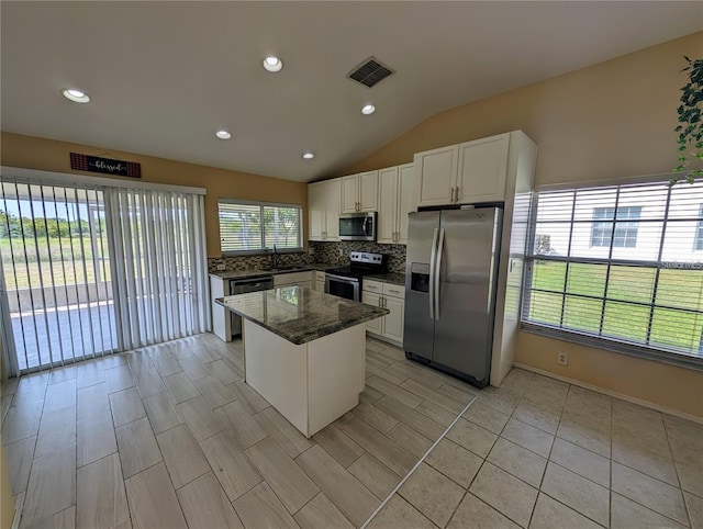 13940 Corrine Key Pl, Orlando, FL 32824 - kitchen featuring stainless steel appliances, a sink, lofted ceiling, tasteful backsplash, and white cabinets
