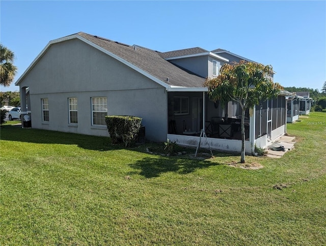 13940 Corrine Key Pl, Orlando, FL 32824 - view of side of property featuring a sunroom, a yard, roof with shingles, and stucco siding