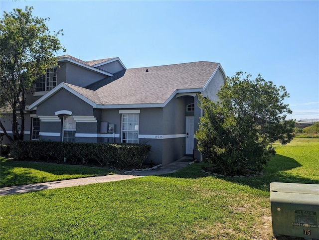 13940 Corrine Key Pl, Orlando, FL 32824 - view of front of house featuring a front yard, stucco siding, and roof with shingles