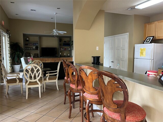 4008 San Gallo Dr Unit 106, Kissimmee, FL 34741 - kitchen with freestanding refrigerator, light brown cabinets, ceiling fan, and light tile patterned floors