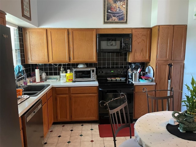 4926 Reginald Rd, Orlando, FL 32829 - kitchen featuring black appliances, light countertops, backsplash, a sink, and light tile patterned floors