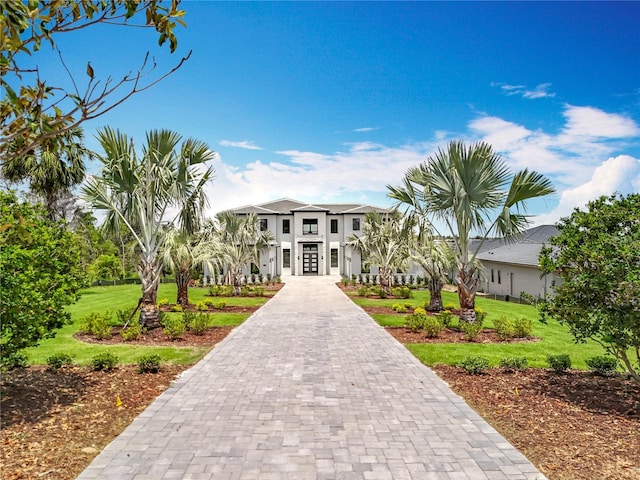 15121 Pendio Dr, Montverde, FL 34756 - view of front of home featuring a front lawn, decorative driveway, stucco siding, and french doors