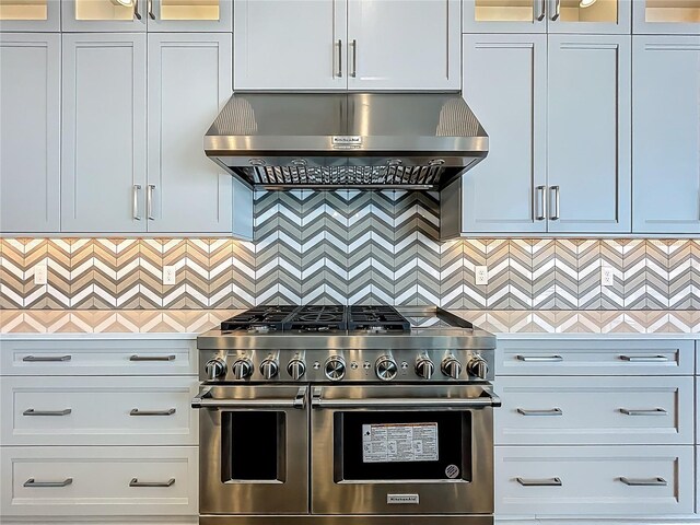 15121 Pendio Dr, Montverde, FL 34756 - kitchen with range with two ovens, exhaust hood, light countertops, and glass insert cabinets
