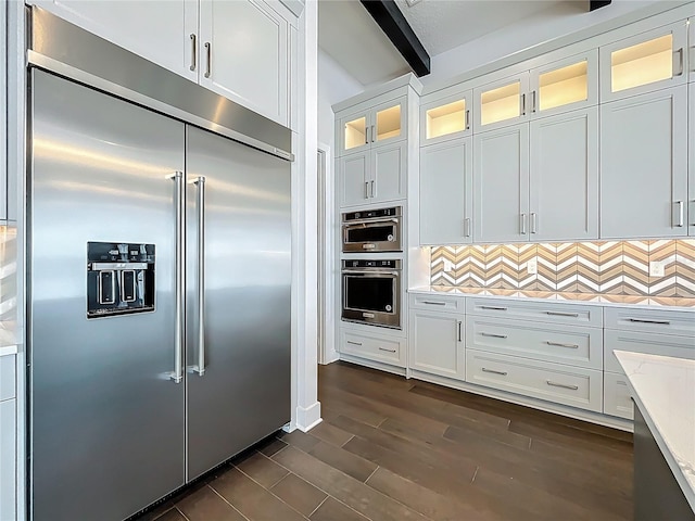 15121 Pendio Dr, Montverde, FL 34756 - kitchen with appliances with stainless steel finishes, beamed ceiling, decorative backsplash, dark wood-style floors, and white cabinetry