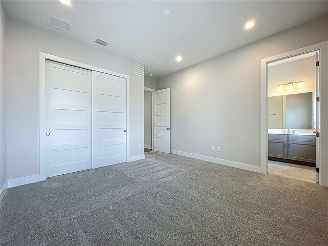 15121 Pendio Dr, Montverde, FL 34756 - unfurnished bedroom with light carpet, a closet, baseboards, recessed lighting, and ensuite bath