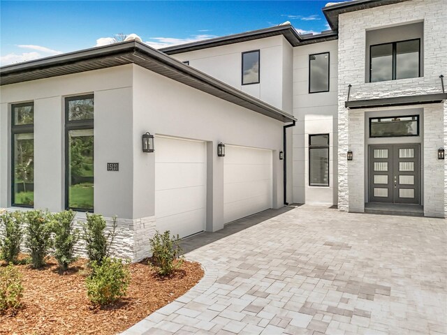 15121 Pendio Dr, Montverde, FL 34756 - view of front of property with stucco siding, decorative driveway, stone siding, and an attached garage