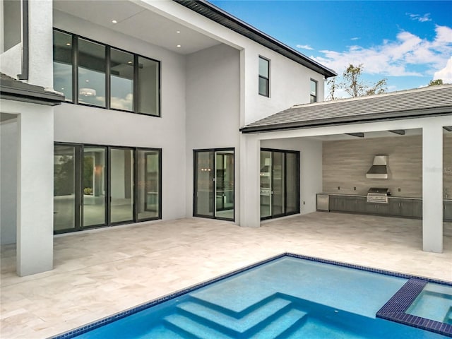 15121 Pendio Dr, Montverde, FL 34756 - back of house featuring area for grilling, stucco siding, a pool with connected hot tub, and a patio