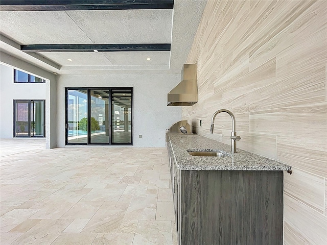 15121 Pendio Dr, Montverde, FL 34756 - kitchen featuring a sink, wall chimney range hood, light stone counters, stone tile floors, and open floor plan