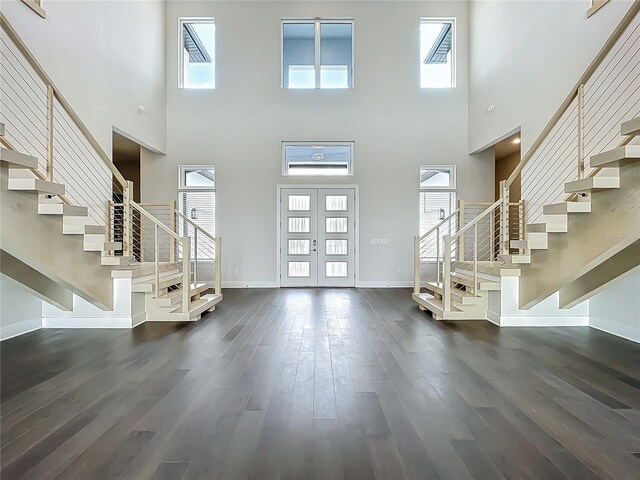 15121 Pendio Dr, Montverde, FL 34756 - foyer featuring stairway, a towering ceiling, dark wood-style floors, baseboards, and healthy amount of natural light