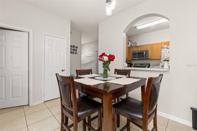 6214 Stevenson Dr Unit 106, Orlando, FL 32835 - dining area with arched walkways, light tile patterned floors, and baseboards