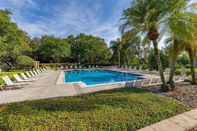 6214 Stevenson Dr Unit 106, Orlando, FL 32835 - community pool featuring a patio area, view of scattered trees, and a lawn
