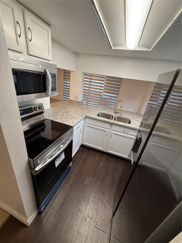 709 Orchid Dr, Davenport, FL 33897 - kitchen featuring stainless steel appliances, a sink, dark wood-style flooring, and white cabinets