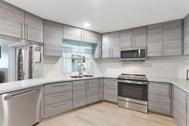 7222 Stanford Dr, Lakeland, FL 33809 - kitchen featuring appliances with stainless steel finishes, a sink, gray cabinets, and modern cabinets