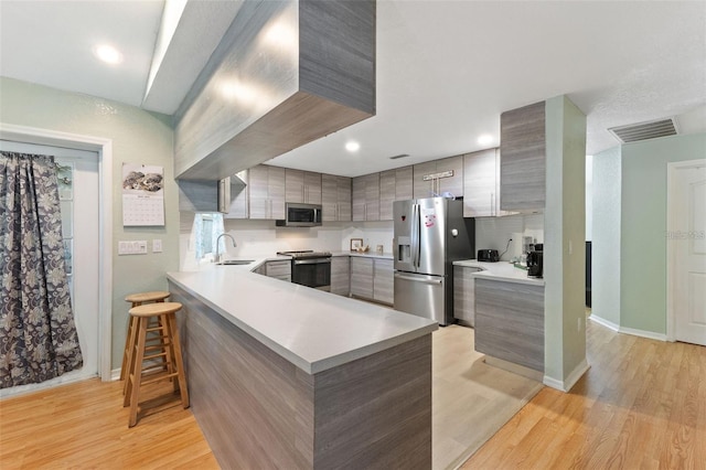 7222 Stanford Dr, Lakeland, FL 33809 - kitchen with appliances with stainless steel finishes, modern cabinets, a sink, light wood-type flooring, and baseboards