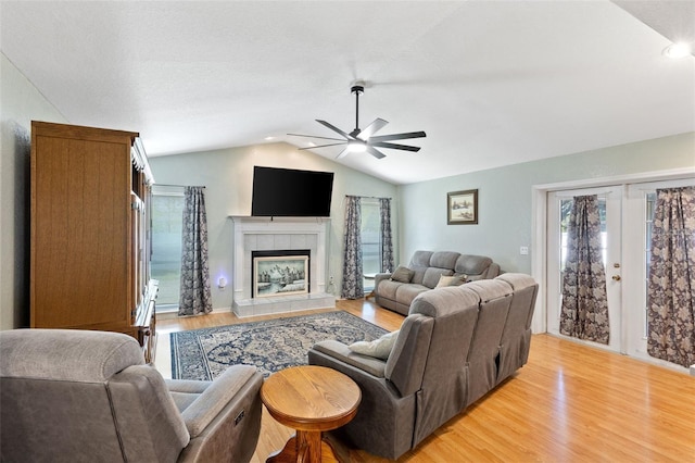 7222 Stanford Dr, Lakeland, FL 33809 - living area with vaulted ceiling, a ceiling fan, light wood-type flooring, a tiled fireplace, and recessed lighting