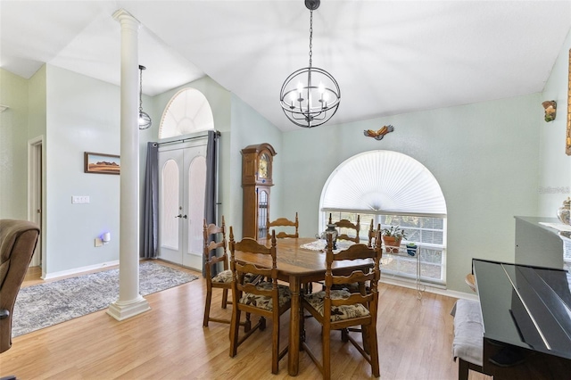 7222 Stanford Dr, Lakeland, FL 33809 - dining space featuring vaulted ceiling, ornate columns, light wood finished floors, a chandelier, and baseboards
