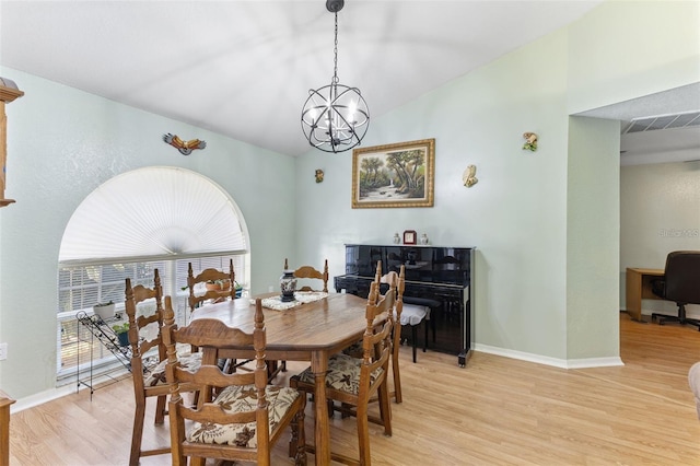 7222 Stanford Dr, Lakeland, FL 33809 - dining room with light wood-style floors, a chandelier, lofted ceiling, and baseboards