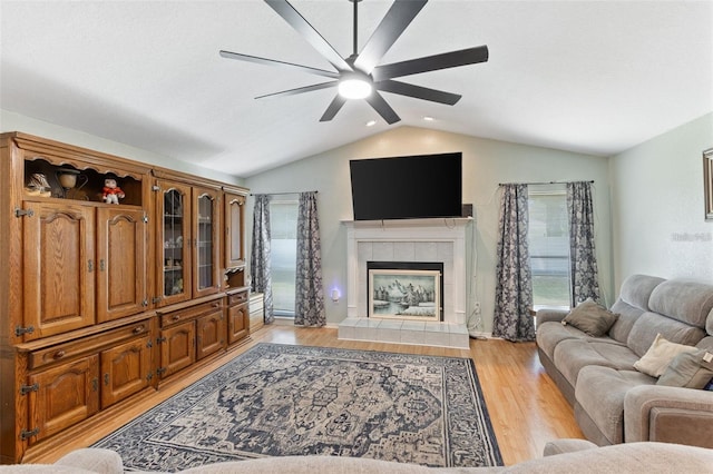 7222 Stanford Dr, Lakeland, FL 33809 - living room featuring vaulted ceiling, a ceiling fan, light wood finished floors, a tiled fireplace, and recessed lighting