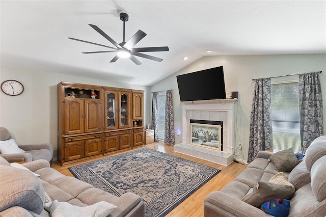 7222 Stanford Dr, Lakeland, FL 33809 - living room with lofted ceiling, ceiling fan, a tiled fireplace, light wood-style flooring, and recessed lighting