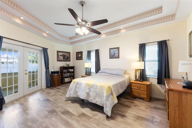 7222 Stanford Dr, Lakeland, FL 33809 - bedroom with a tray ceiling, french doors, access to exterior, light wood-style flooring, and a ceiling fan